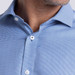 A close-up of a men's button-up shirt featuring a blue checkered pattern and white buttons. The shirt has a logo.