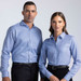 A blue button-up shirt worn by a man and a woman, featuring a collar and a logo.