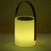 A lamp-shaped speaker in soft yellow with a metal handle and a speaker grating on top. It features a minimalist design.