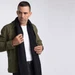 A man wearing a black 100% Merino scarf over a white shirt and green jacket. The scarf is long and drapes naturally.