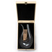 A sleek black glass decanter displayed in a wooden box with a black velvet lining. It features a branding logo.