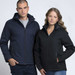 A navy soft shell jacket and a black soft shell jacket are worn by a male and a female model. Both jackets have hoods and zippers.