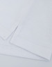 A close-up of a white cotton/poly pique fabric with folded edges, featuring a logo on the corner.