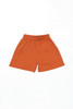 Youth Core Shorts in bright orange with an elastic waistband and a simple design. Features branding.
