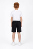 Youth Core Shorts in black, featuring an elastic waistband, shown on a child from the back, wearing a white t-shirt and shoes.