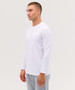A white long sleeve tee displayed on a model, featuring a simple design and a logo on the chest.