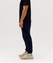 Navy track pants worn by a person, paired with a black t-shirt and light-coloured sneakers. The design features a logo.