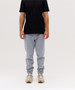 Light grey track pants with a fitted design, paired with a black t-shirt, featuring a logo on the shirt.