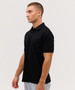 A black polo shirt displayed on a model in profile, featuring a collar and short sleeves. The shirt has a logo.