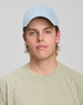 A light blue jacquard texture 5 panel cap worn by a young man, paired with a beige T-shirt.