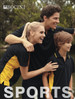 A family wearing black polo shirts with yellow accents, smiling outdoors by a body of water. The shirts feature a logo.