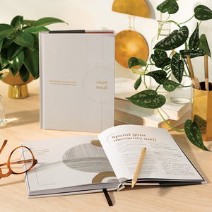 Lifestyle photo of "Smart Small: Intentions and Activities to Create a Life You Love", an activity book and guided journal. Journal is open to a page with prompts for self-care and well-being.
