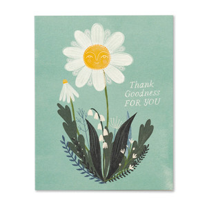 The front of this thank you card features an illustration of a white flower with a yellow center and face with a bright smile, the background is light green and has other foliage around the white flower, and the statement "Thank goodness for you".