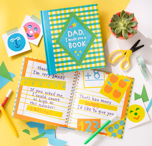 This is a lifestyle photo of the fill-in book "Dad, I Made You a Book". The book is open to a page that reads "If you asked me, I could count as high as this number [fill in the blank]. That's how many [fill in the blank] I'd like to give you."