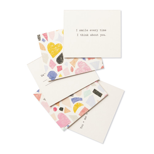 Multi-card view, a playful set of compliment cards for someone special, bright and colorful sleeved box, features elegant gold foil stamping, includes 20 cards, each with a unique messages. Message on this card is "I smile every time I think about you"