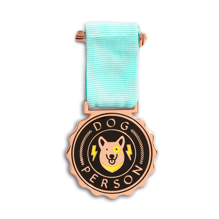 An award medal with a teal blue ribbon and an illustration that reads “Dog Person”