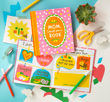 This is a lifestyle photo of the fill-in book "Mom, I Made You a Book". The book is open to a page that has options to pick from that include, "Kisses. Hugs. Snuggles. Reading together. Or write your own/fill in the blank."