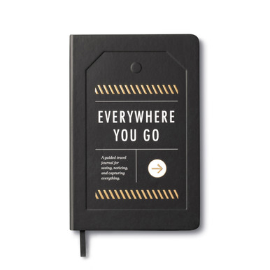 The front cover from "Everywhere You Go: a guided journal for seeing, noticing, and capturing everything" travel notebook. The softcover journal is black with white and gold foil accents.