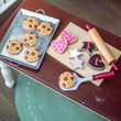 In 18 inch doll kitchen, the 8 piece chocolate chip cookie set and 8 piece cookie baking set are seen from above. In 18 inch doll kitchen, the 8 piece chocolate chip cookie set and 8 piece cookie baking set are seen from above.