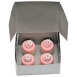 Against white background the 4 mini cupcakes are inside an open white bakery box. Against white background the 4 mini cupcakes are inside an open white bakery box.