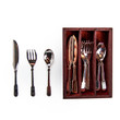 A set of doll-sized silverware is arranged on a solid white background. To the left, a single metal butter knife, fork, and spoon stand vertically in a row. To the right, a rectangular, dark reddish-brown wooden organizer tray holds the rest of the set, with slots neatly separating stacks of matching miniature knives, forks, and spoons.