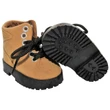 A pair of miniature tan faux-suede work boots designed for 18-inch dolls, set against a plain white background. One boot stands upright, showing its black laces, three pairs of silver metal eyelets, and a thick, textured black sole. The second boot is tilted on its side next to it, prominently displaying the deeply grooved lug pattern on its black rubber-like outsole.