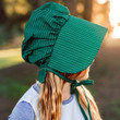 Detail of the green bonnet worn by child model.