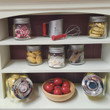 Close up of  doll hutch shelves filled with 18 inch doll sized mason jars with assorted food items.