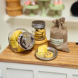Close up shot of 18 inch doll  sized food in jars on counter. Food is cheese wedges and chocolate chip cookies.
