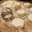Biscuit dough shown on a floured bread board with a biscuit cutter.