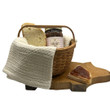 Basket containing Little House on the Prairie Apple Jam, bread, and a kitchen towel on a pig shapped cutting board with a white background