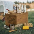 A 18 inch doll baking display featuring cloth flour and sugar sacks, white milk bottles, and a mixing bowl arranged on a wooden crate labeled "Ingalls Independence, KS" in a grassy field authentic Little House on the Prairie product