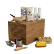 A vintage baking display featuring cloth flour and sugar sacks, white milk bottles, and a mixing bowl arranged on a wooden crate labeled "Ingalls Independence, KS" on a white background