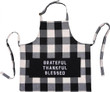 Black and with buffalo check apron with a solid black 3 part pocket. On the pocket the words Grateful, Thankful, Blessed. Apron has a bib and ties around the waist, with an adjustable strap for the neck. This is on a white background/