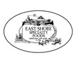 An oval-shaped black and white logo for East Shore Specialty Foods. The center features an illustration of a lakeside country house or cabin situated above a sign that reads "EAST SHORE SPECIALTY FOODS established with pride in 1986." A small wooden dock extends into the water in the foreground, flanked by reeds and stones.