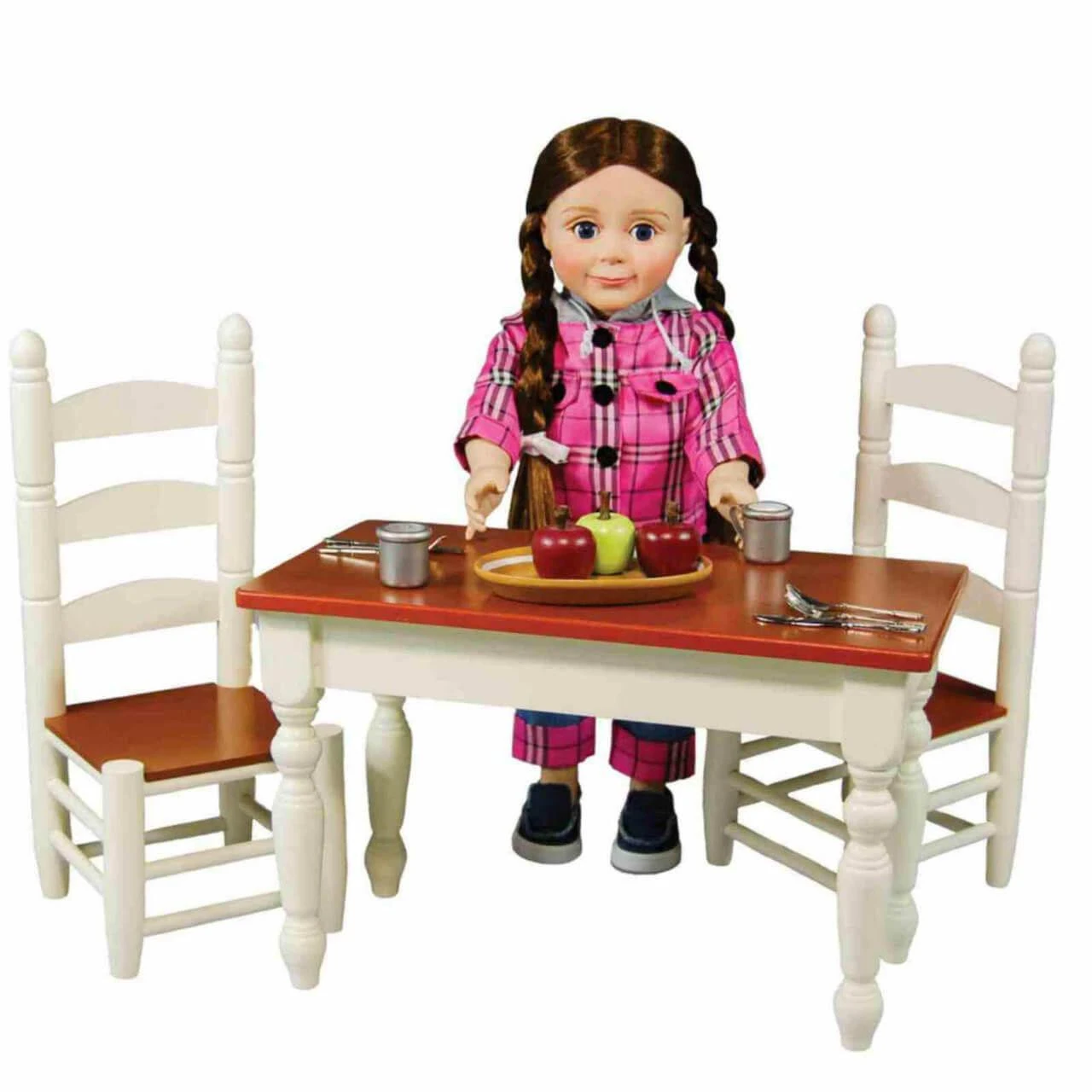 An 18-inch doll with long brown hair in braids stands behind a miniature wooden dining set by The Queen's Treasures® against a white background. She wears a pink and purple plaid pajama set with dark shoes. The set features a white painted table with a dark natural wood top, flanked by two matching white ladder-back chairs with dark wood seats. A small wooden tray with play apples and miniature silver cups sits on the table.