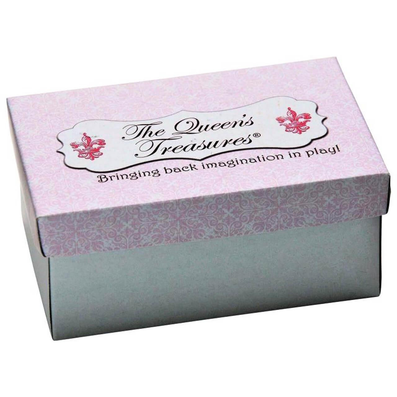 A small rectangular doll shoe box with a white base and a glittery pale pink lid against a plain white background. The top of the lid features a white decorative label reading "The Queen's Treasures®" in black cursive script, flanked by two pink fleur-de-lis symbols, with the slogan "Bringing back imagination to play!" printed underneath.