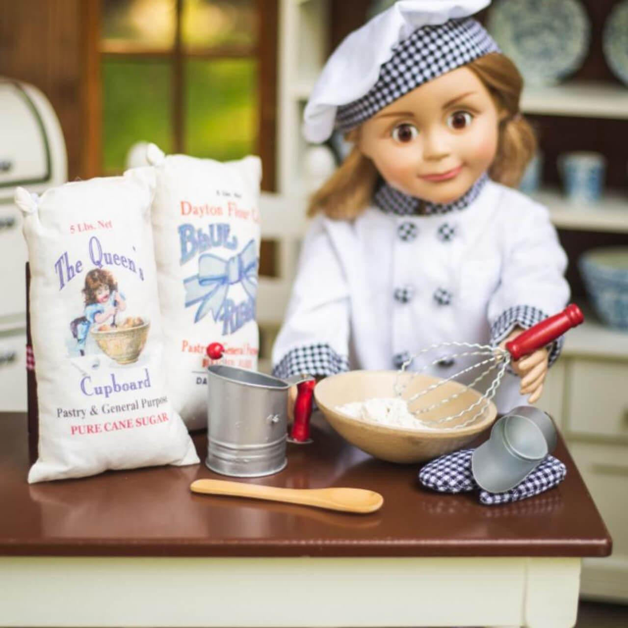 In doll kitchen play scene, an 18 inch Pastry Chef doll works with mixing bowl over our 18 inch doll kitchen table.