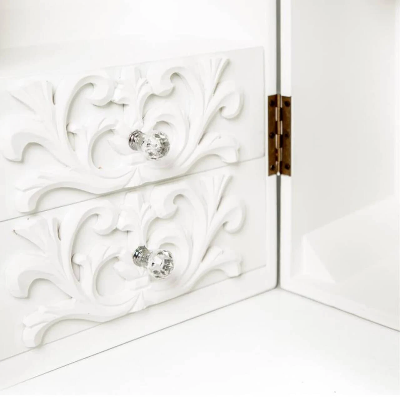 A close up view of the French molding and clear knob details on the trunk's drawers.