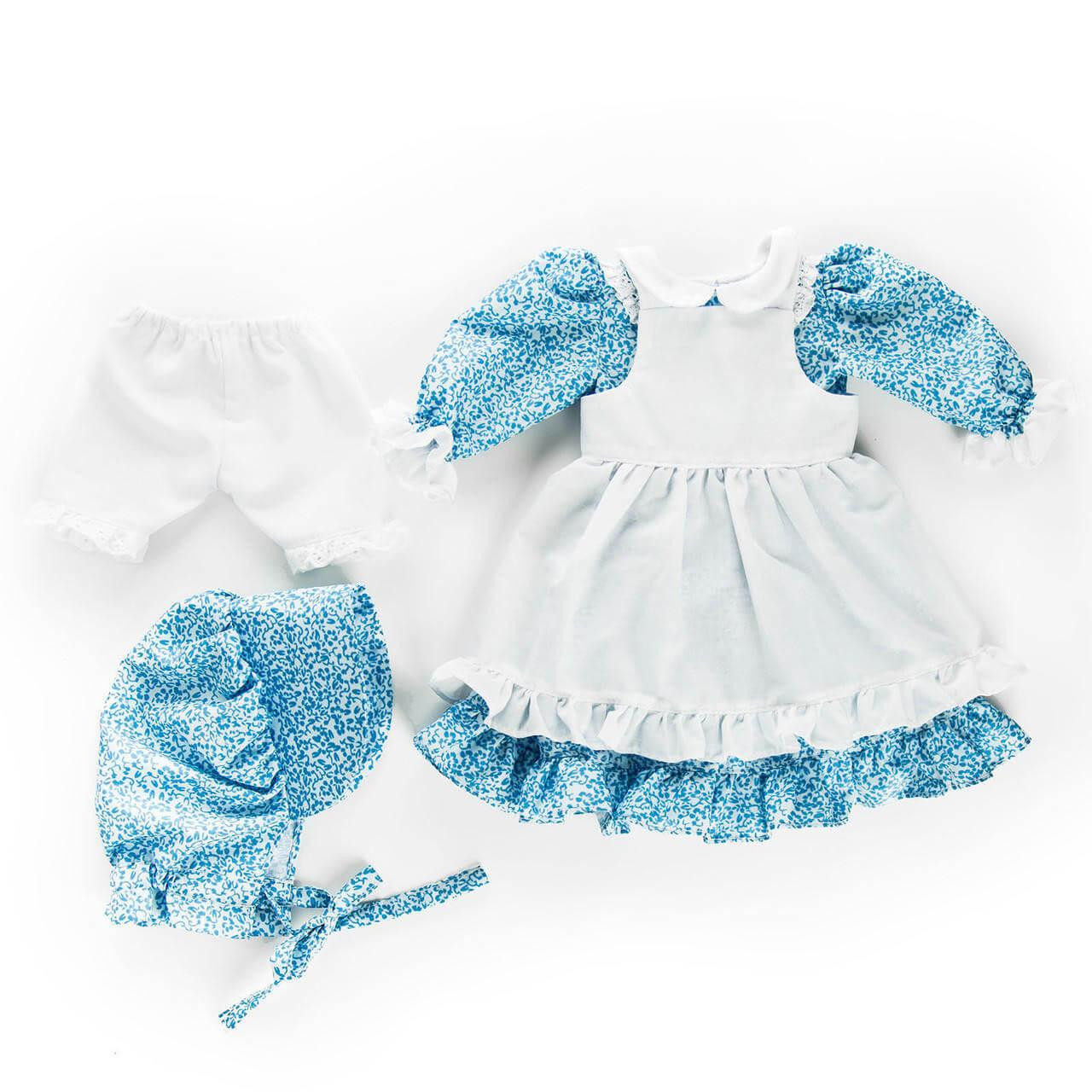 A blue floral calico pioneer dress shown flat against a white background, arranged with a matching fabric bonnet, white ruffled pinafore apron, and separate white bloomers.