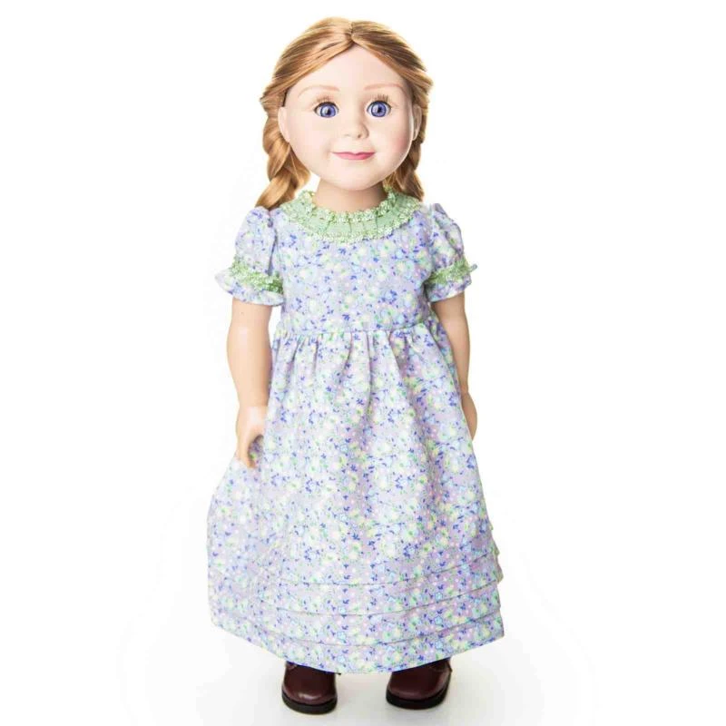 An 18-inch doll with braided blonde hair wearing a purple and green calico pioneer dress by The Queens Treasures®.