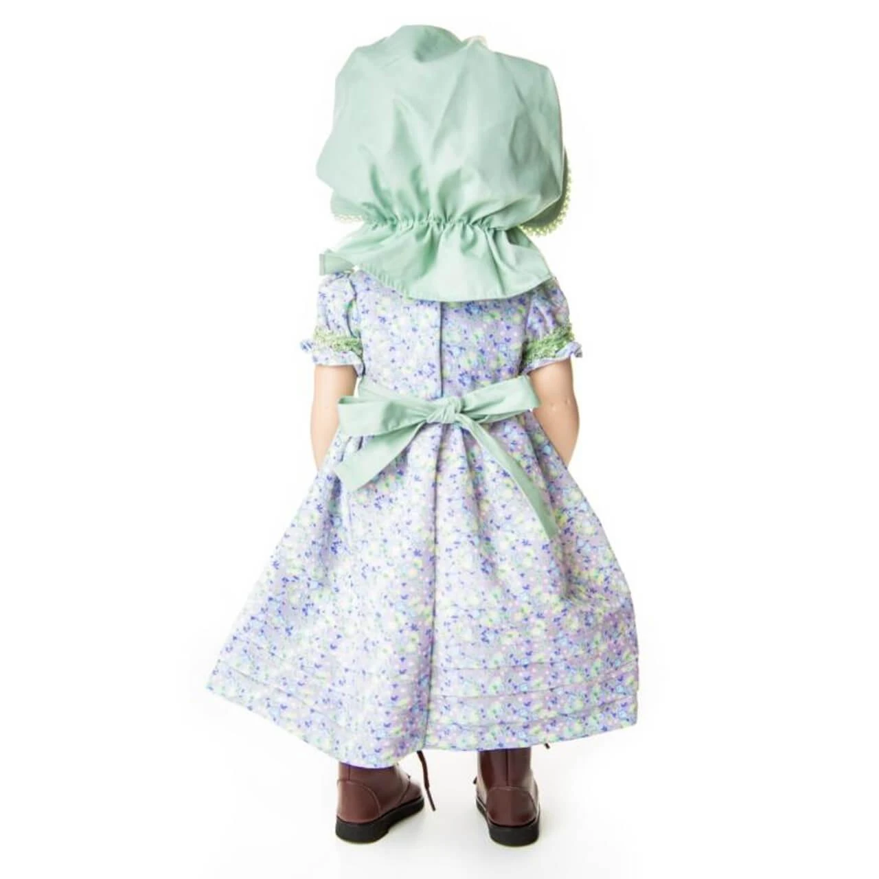 Rear view of an 18-inch doll wearing a green bonnet, purple calico dress with a back tie bow, and brown boots.