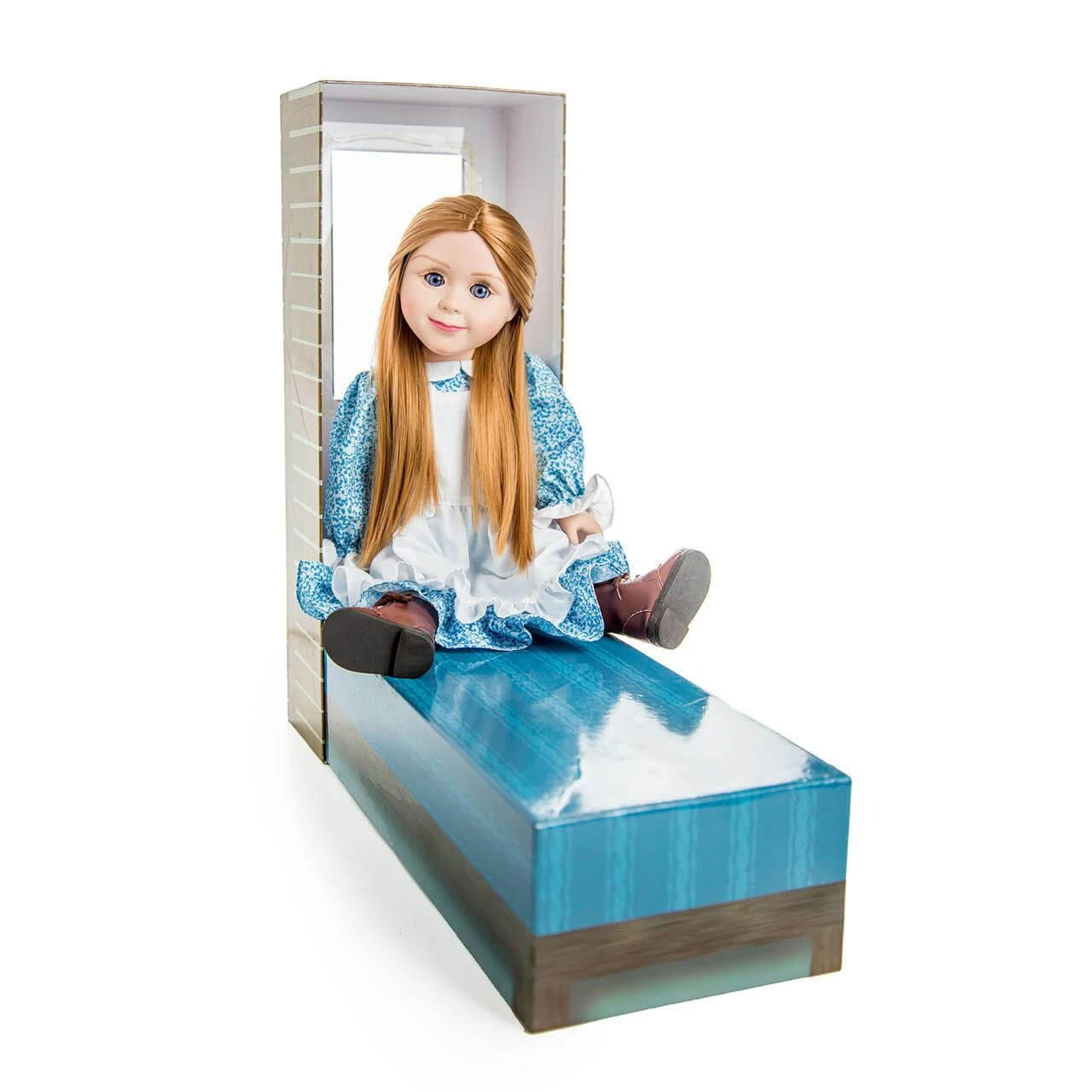 An 18-inch doll sits on a convertible doll bed made from its log-cabin style packaging box..