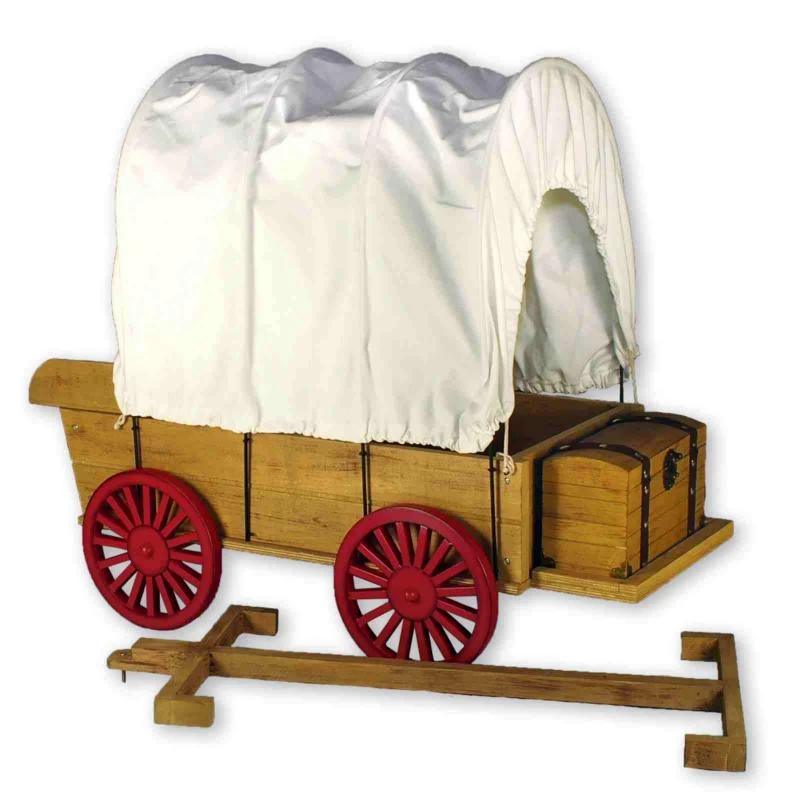 A miniature wooden pioneer-style covered wagon with a white fabric canopy and bright red spoked wheels, scaled perfectly for 18" American Girl® Dolls, displayed alongside a hitching mechanism and an integrated storage chest.