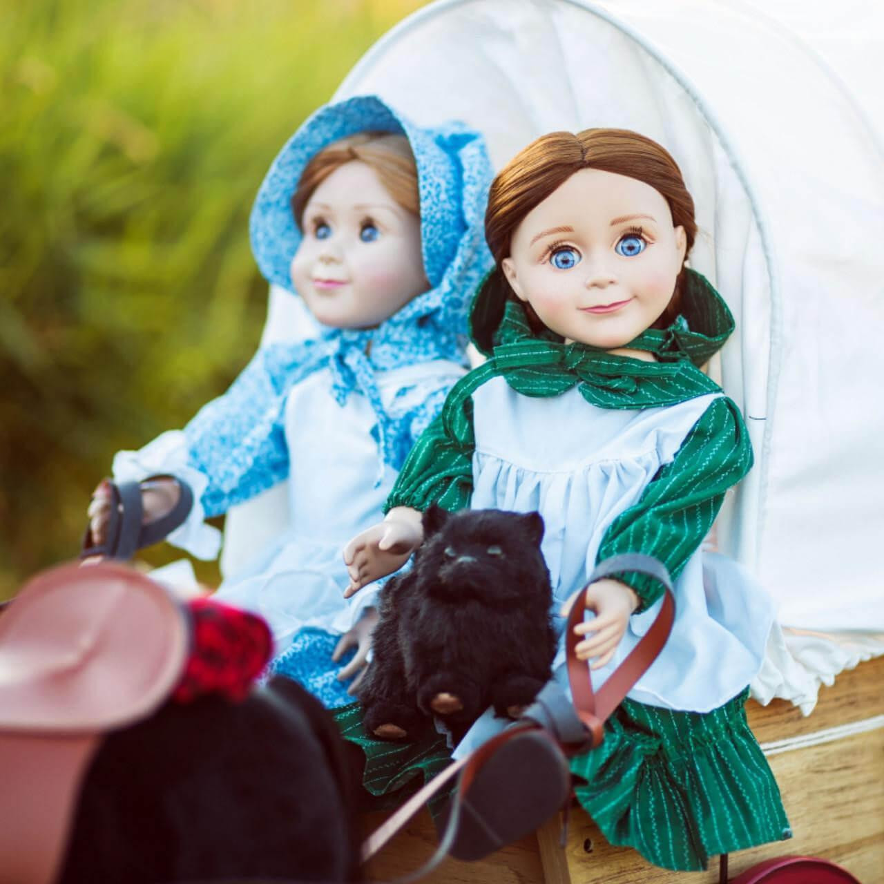 Laura Ingalls and Mary Ingalls 18 inch dolls in our little house prairie dresses, sitting in our covered wagon.  Compatible with american girl dolls made after 2008.