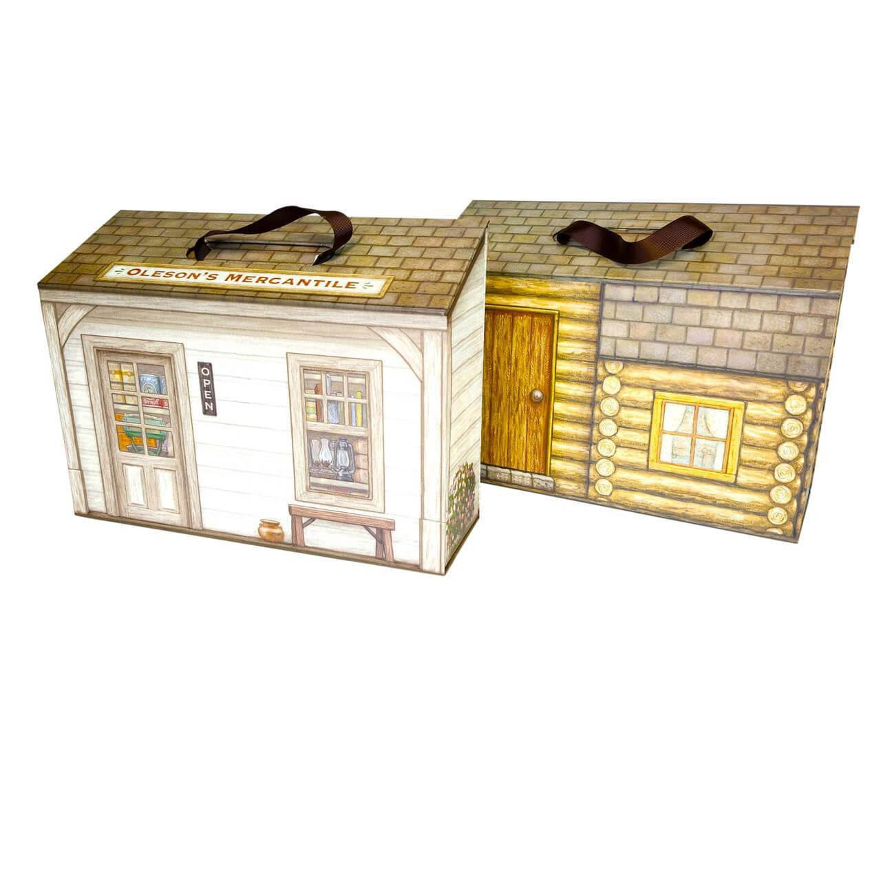 Two closed miniature suitcase playsets with fabric handles are displayed against a white background, featuring a general store facade labeled "Oleson's Mercantile" on the left and a log cabin pattern on the right.