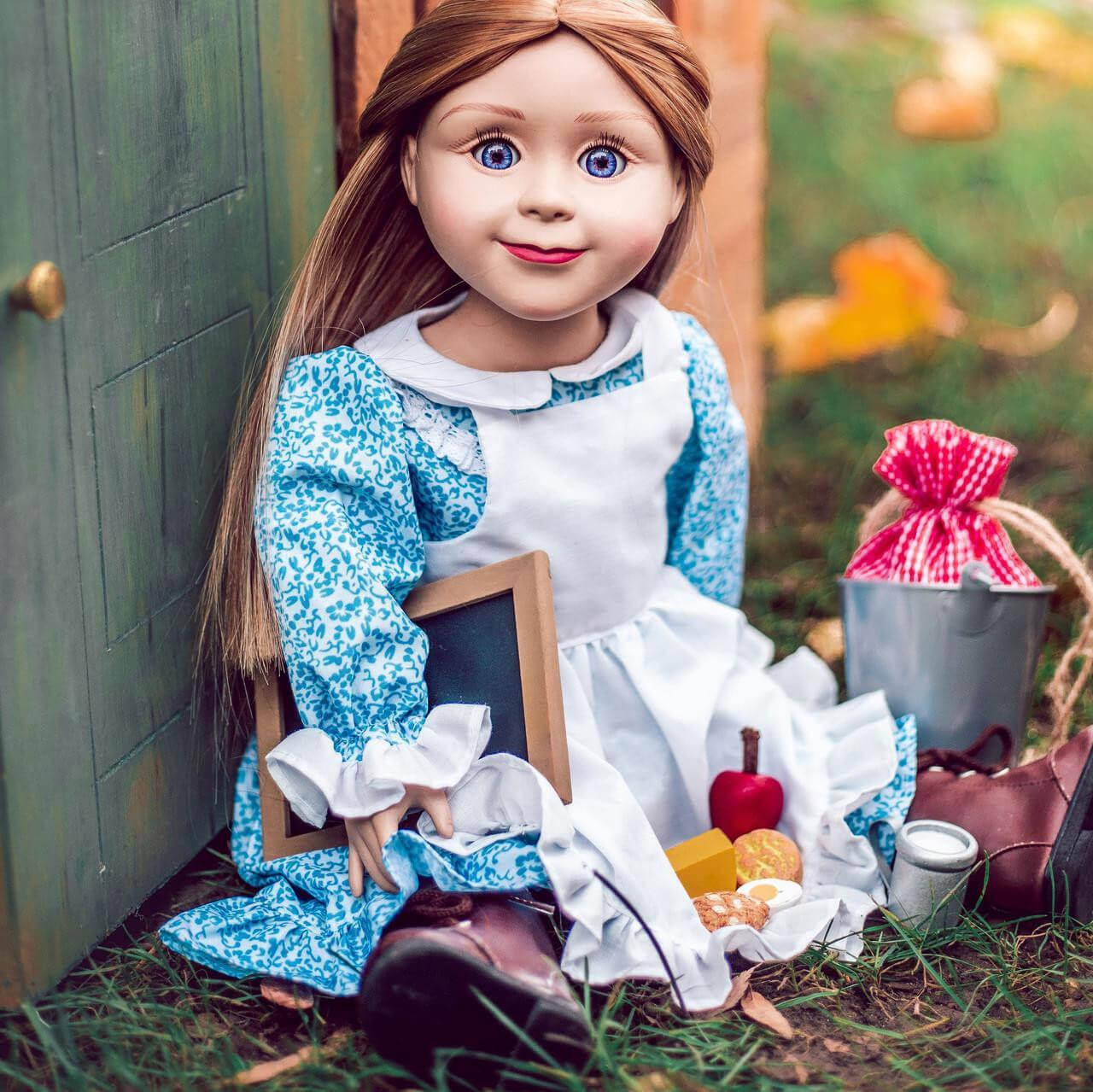 In outdoor scene our Mary Ingalls doll sits outside in the blue 18" doll dress and 18" doll accessories are beside her.