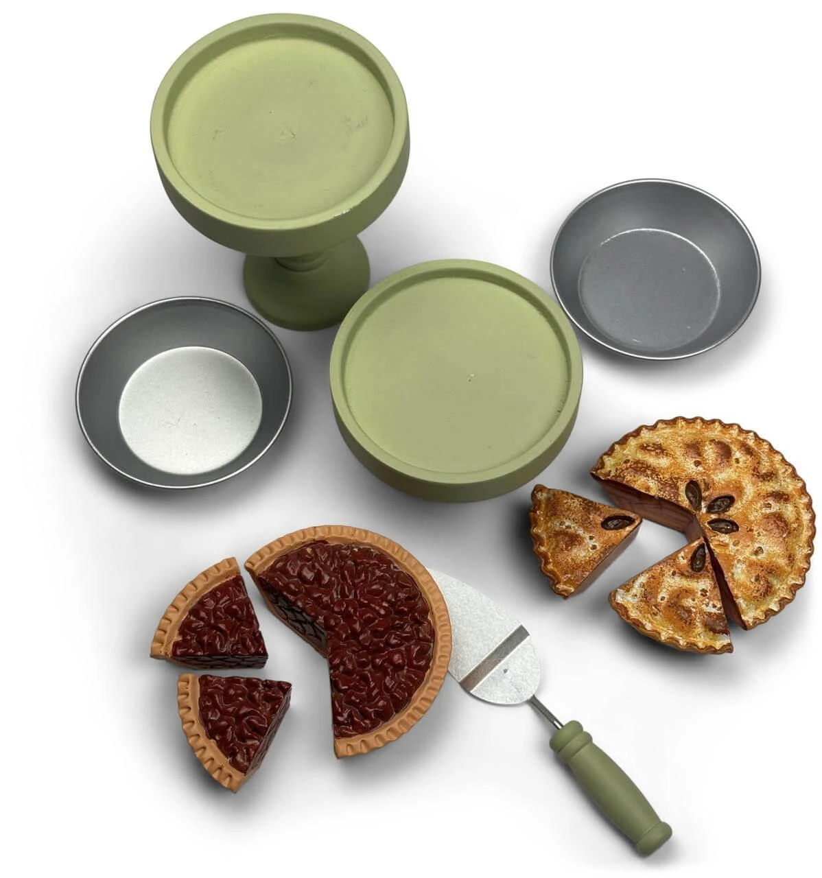 Against white background, all 11 pieces of 18 inch doll Baker Set are displayed. They are the two green pie stands, apple and pecan pies with 2 slices each pre-cut, two metal pie plates to each hold a pie and the green handled pie server utensil.