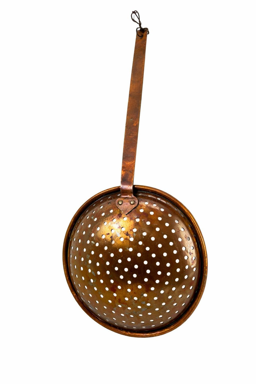 Underside angle of antique perforated copper skimmer showing bowl depth and handle connection