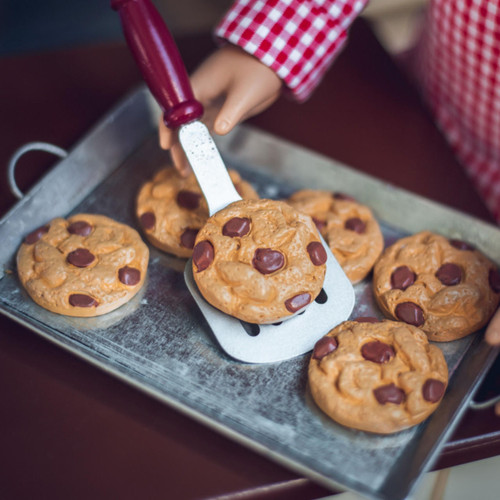 In doll kitchen, a chocolate chip cookie of 18 inch doll baked goods is being served on the spatula. In doll kitchen, a chocolate chip cookie of 18 inch doll baked goods is being served on the spatula.